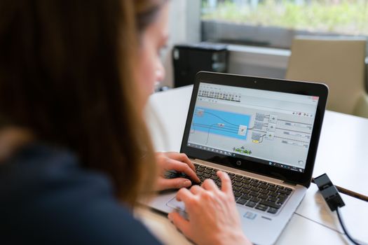 Home A woman engineer focuses on software analysis using a laptop indoors.